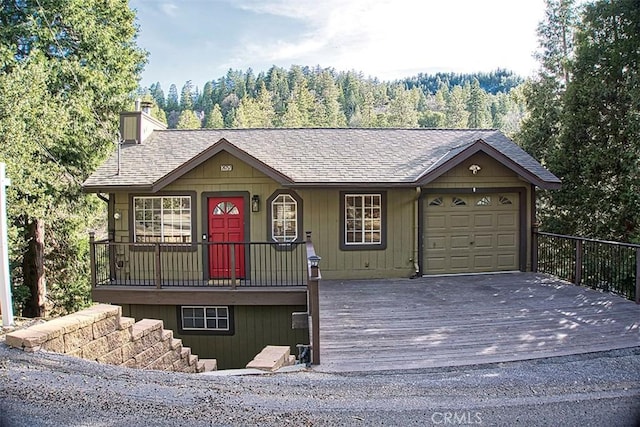 view of front of home with driveway, a chimney, a garage, and roof with shingles