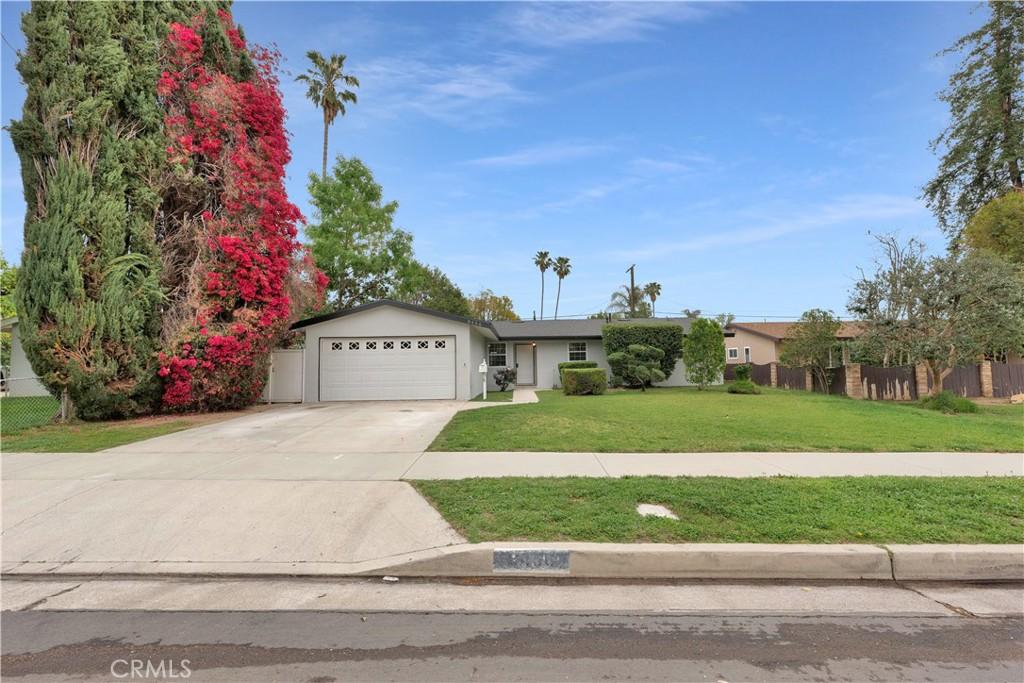 8456 Lurline Ave, Winnetka, CA 91306 - view of front of house with fence, an attached garage, stucco siding, a front yard, and driveway