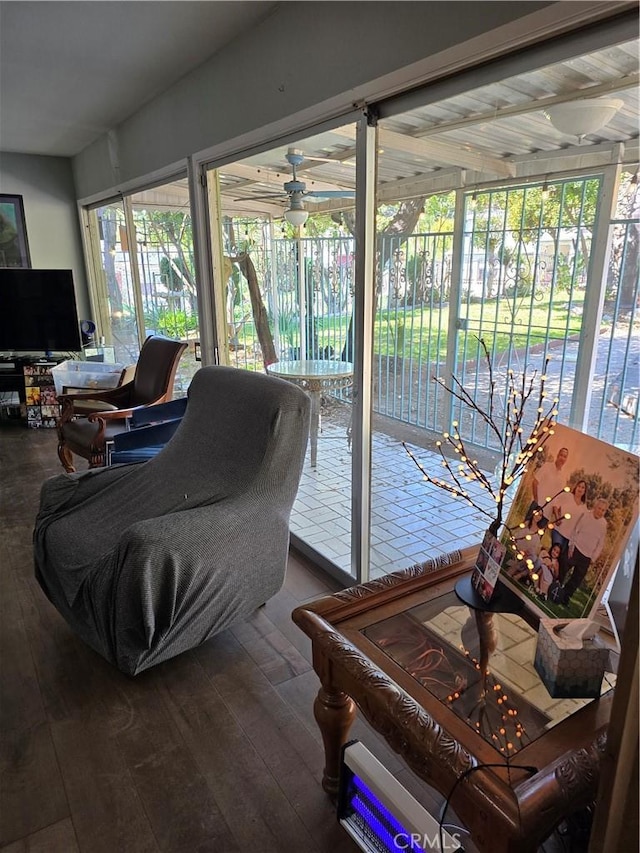 living room with plenty of natural light, dark wood finished floors, and a ceiling fan
