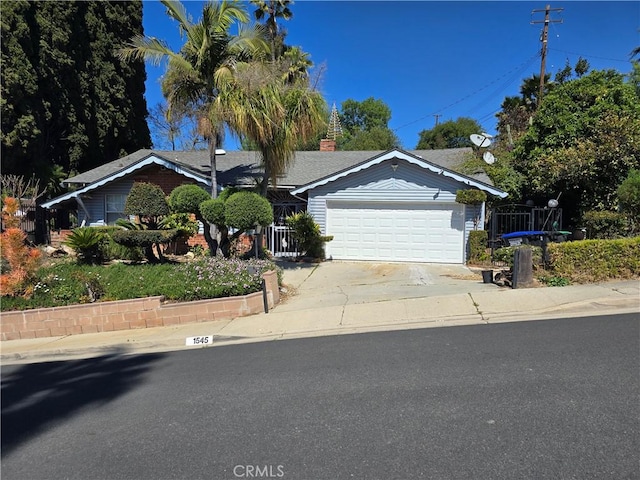 single story home featuring driveway, a garage, and a chimney