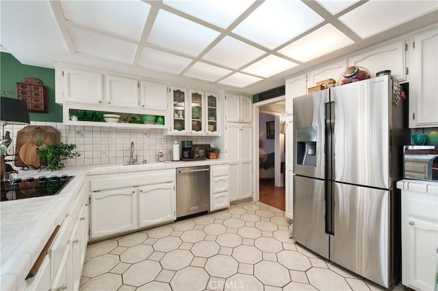 31065 Avenida Del Reposo, Temecula, CA 92591 - kitchen with decorative backsplash, a sink, white cabinets, tile counters, and stainless steel appliances
