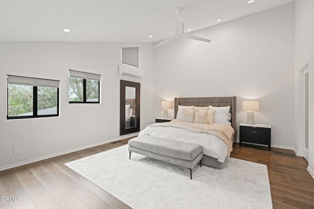 bedroom featuring an AC wall unit, baseboards, high vaulted ceiling, and recessed lighting
