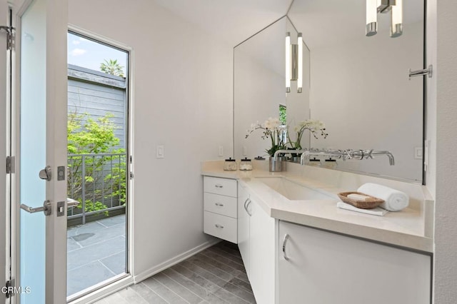 bathroom featuring vanity, baseboards, and wood finished floors