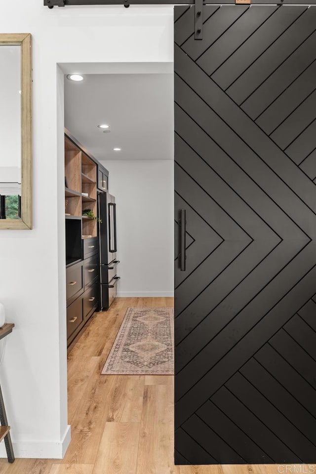hall featuring light wood-style floors, recessed lighting, and baseboards