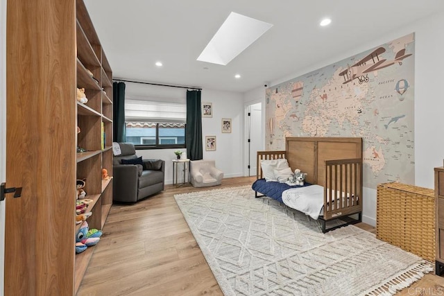 bedroom featuring a skylight, recessed lighting, and light wood-style floors