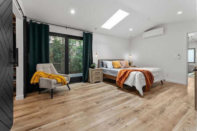 bedroom with an AC wall unit, vaulted ceiling, a skylight, light wood-style flooring, and recessed lighting