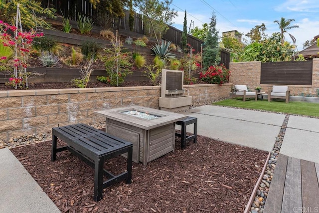 view of patio / terrace featuring an outdoor fire pit and a fenced backyard