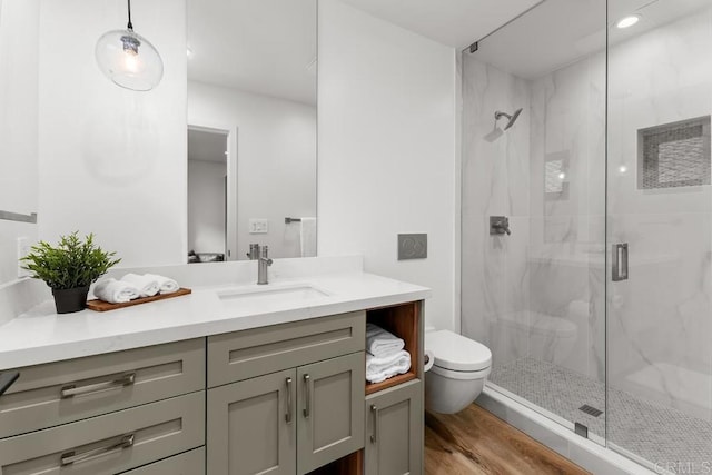 full bathroom with a marble finish shower, toilet, vanity, wood finished floors, and recessed lighting