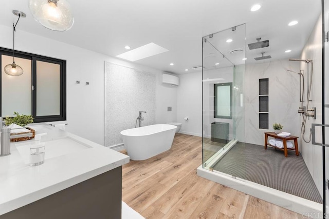 5186 Maynard St, San Diego, CA 92122 - bathroom with a wall unit AC, a stall shower, wood finished floors, vanity, and a skylight