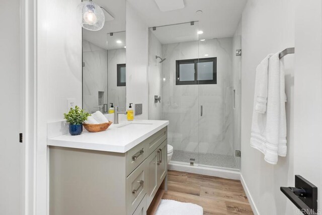 5186 Maynard St, San Diego, CA 92122 - bathroom with a marble finish shower, vanity, and wood finished floors
