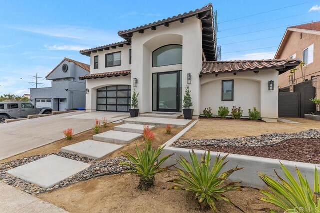 5186 Maynard St, San Diego, CA 92122 - mediterranean / spanish-style home featuring a tile roof, concrete driveway, stucco siding, and a garage