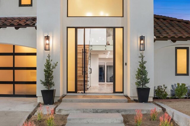 5186 Maynard St, San Diego, CA 92122 - entrance to property featuring a tiled roof, a garage, and stucco siding