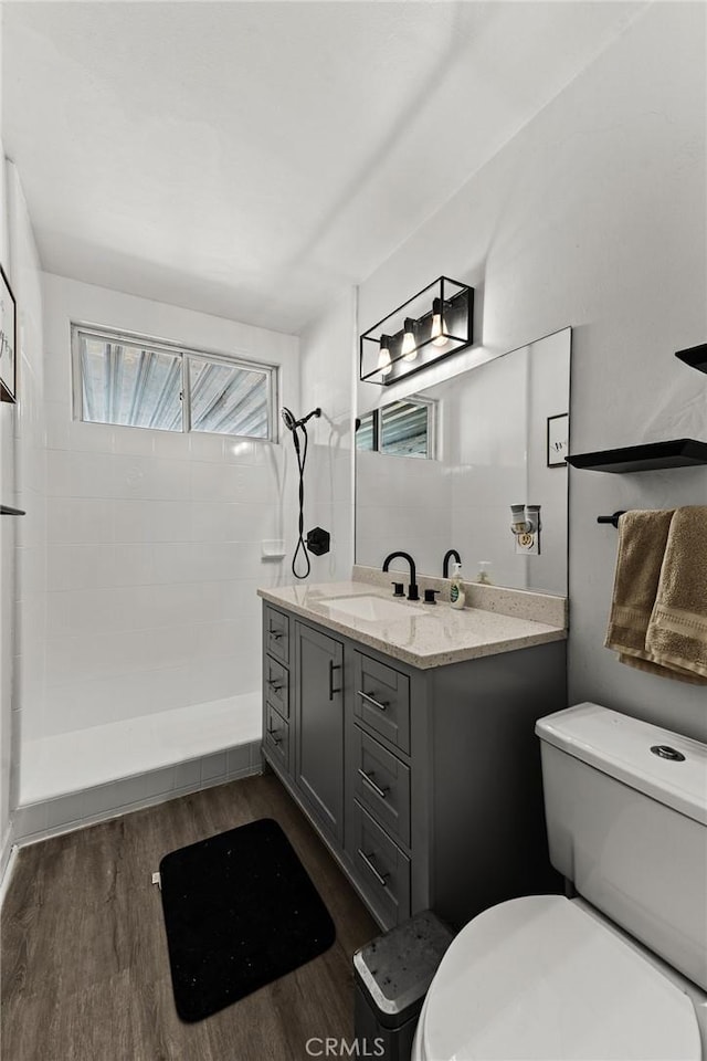 11525 Corby Ave, Norwalk, CA 90650 - bathroom featuring vanity, toilet, tiled shower, and wood finished floors