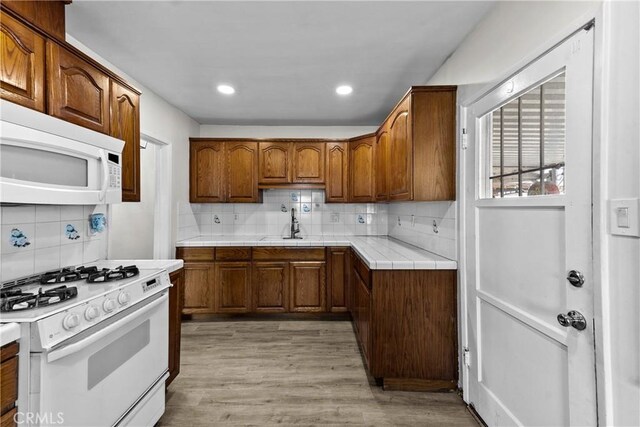 11525 Corby Ave, Norwalk, CA 90650 - kitchen with white appliances, tasteful backsplash, tile counters, brown cabinetry, and recessed lighting