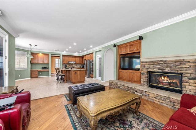 991 Clear Sky Pl, Simi Valley, CA 93065 - living area with ornamental molding, a stone fireplace, recessed lighting, and light wood-style floors