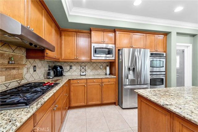 991 Clear Sky Pl, Simi Valley, CA 93065 - kitchen featuring appliances with stainless steel finishes, under cabinet range hood, brown cabinets, light tile patterned floors, and tasteful backsplash