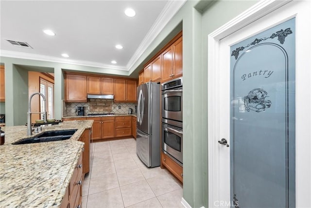 991 Clear Sky Pl, Simi Valley, CA 93065 - kitchen featuring under cabinet range hood, ornamental molding, stainless steel appliances, decorative backsplash, and brown cabinets