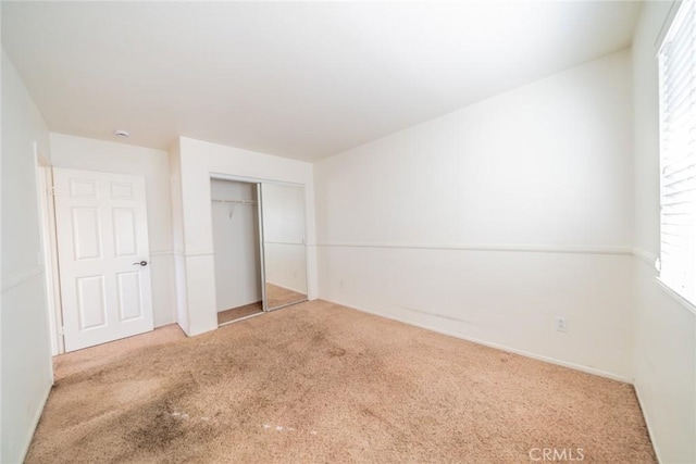 unfurnished bedroom with a closet and carpet flooring