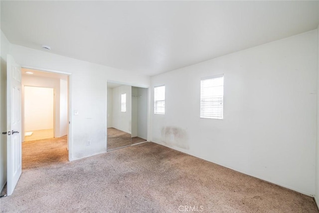 unfurnished bedroom with a closet and carpet floors