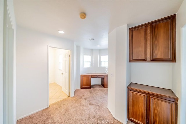 hallway with light colored carpet and visible vents
