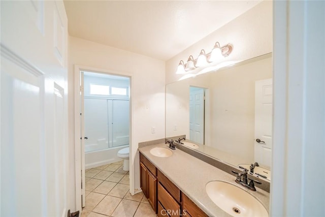 bathroom with double vanity, a sink, tile patterned floors, and toilet