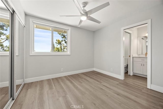 unfurnished bedroom featuring light wood-type flooring, baseboards, and multiple windows