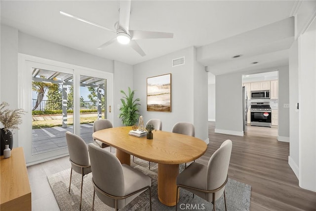 dining space with light wood-type flooring, baseboards, a ceiling fan, and visible vents