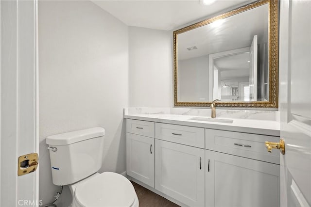bathroom featuring wood finished floors, visible vents, toilet, and vanity