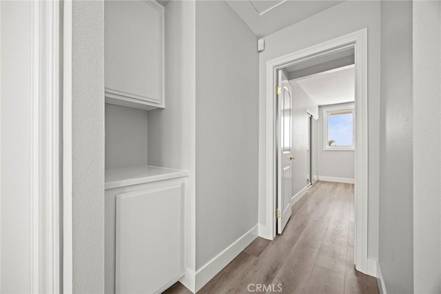 hall with baseboards and wood finished floors