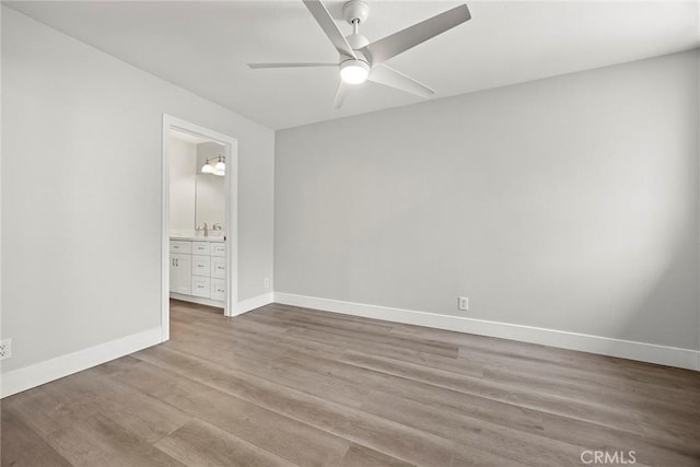 empty room with ceiling fan, baseboards, and light wood-style flooring