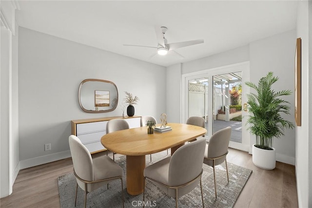 dining space featuring light wood-style flooring, a ceiling fan, and baseboards