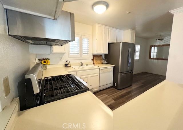 1775 Ohio Ave Unit 213, Long Beach, CA 90804 - kitchen with appliances with stainless steel finishes, light countertops, a sink, ventilation hood, and dark wood-type flooring
