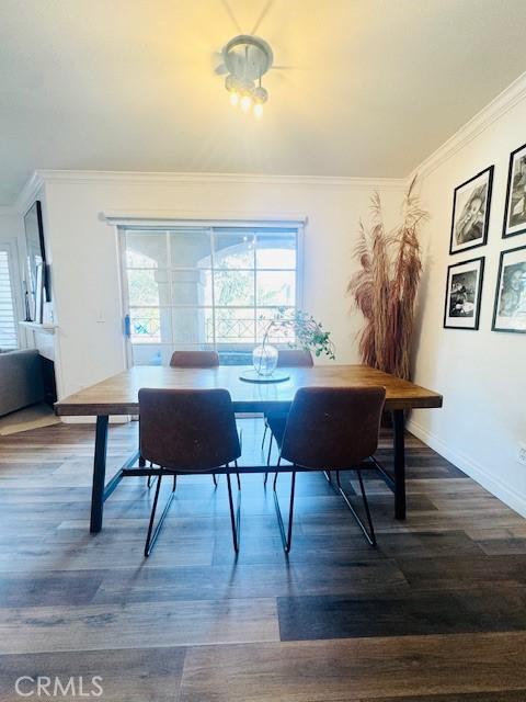 1775 Ohio Ave Unit 213, Long Beach, CA 90804 - dining area featuring dark wood-type flooring, baseboards, a wealth of natural light, and crown molding