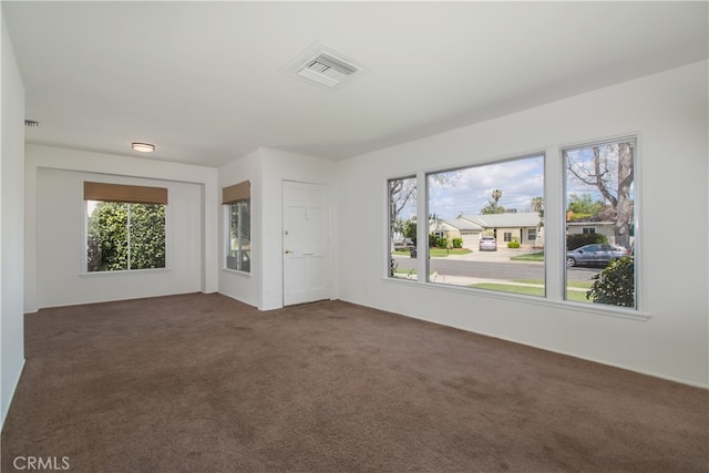 unfurnished room featuring carpet flooring, plenty of natural light, and visible vents