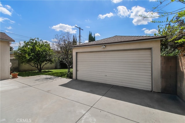 detached garage featuring fence