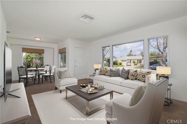 carpeted living room featuring a healthy amount of sunlight and visible vents
