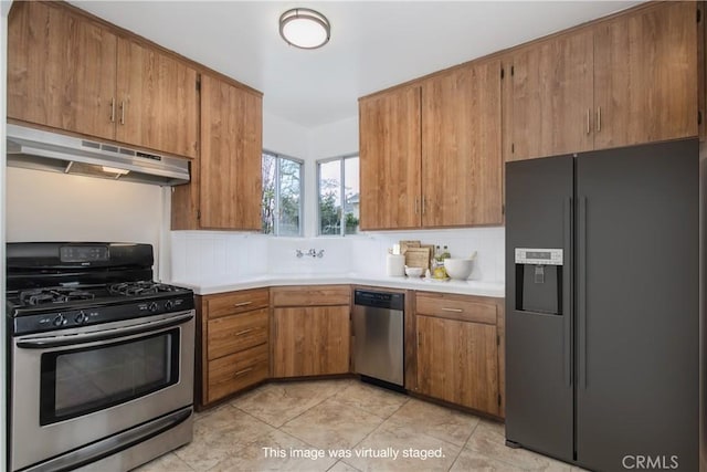 kitchen featuring under cabinet range hood, light countertops, tasteful backsplash, and appliances with stainless steel finishes