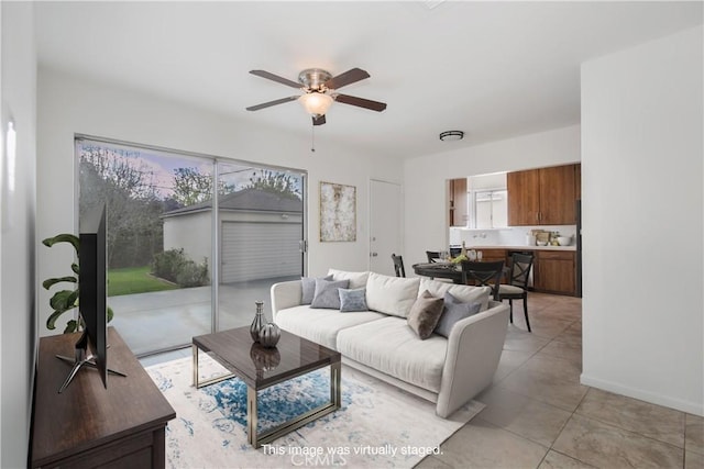 living room with a ceiling fan, light tile patterned floors, and baseboards
