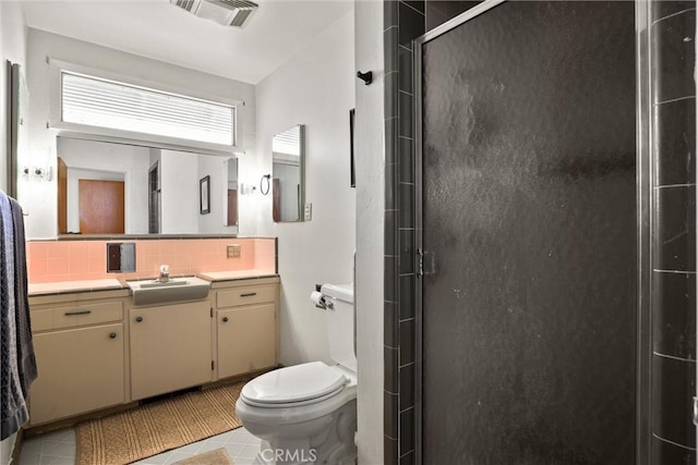 bathroom featuring toilet, a stall shower, visible vents, backsplash, and tile patterned flooring