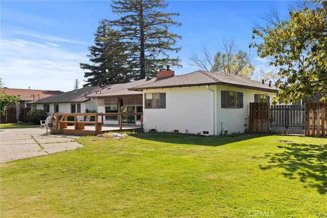 back of property featuring crawl space, a chimney, fence, a yard, and stucco siding