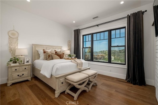 bedroom featuring baseboards, visible vents, wood finished floors, and recessed lighting