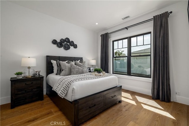 bedroom featuring light wood-type flooring, recessed lighting, baseboards, and visible vents