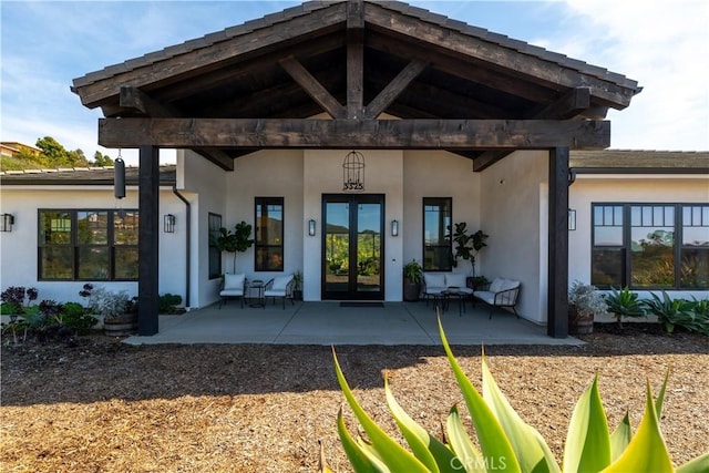 property entrance with stucco siding and french doors