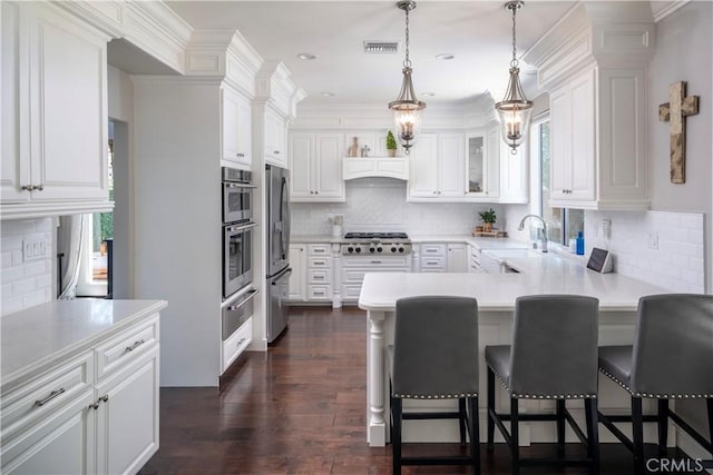 27705 Essex Pl, Valencia, CA 91354 - kitchen featuring a peninsula, decorative backsplash, stainless steel appliances, white cabinetry, and crown molding