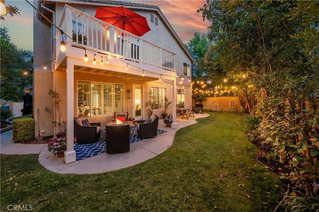27705 Essex Pl, Valencia, CA 91354 - back of property at dusk with stucco siding, an outdoor hangout area, a yard, a patio area, and a balcony
