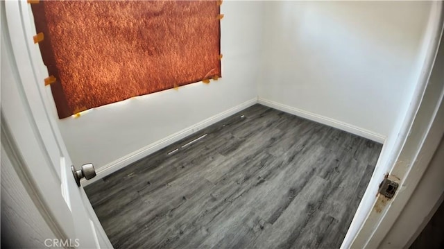 empty room with dark wood-style floors and baseboards