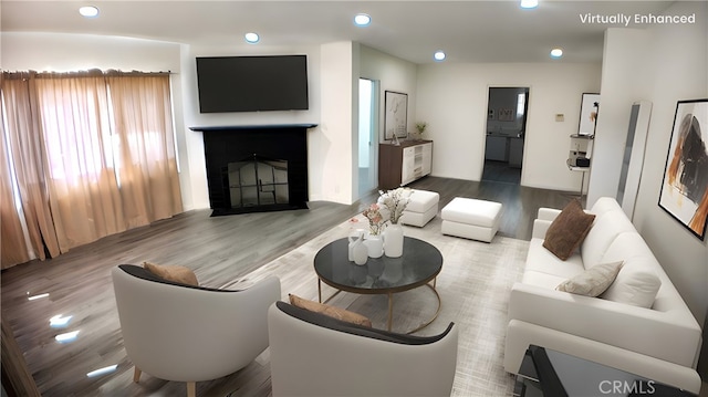 living room with recessed lighting, a fireplace, and wood finished floors