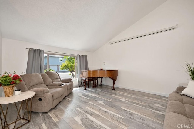 living area with baseboards, light wood finished floors, and lofted ceiling