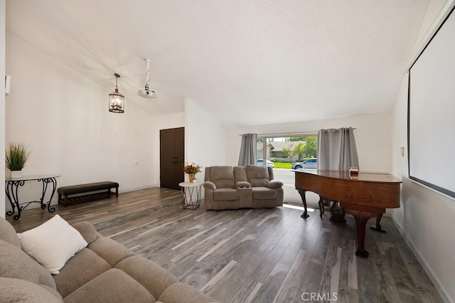 living area featuring wood finished floors, lofted ceiling, and baseboards