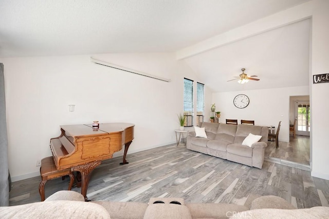 living area with wood finished floors, a ceiling fan, vaulted ceiling with beams, and a wealth of natural light